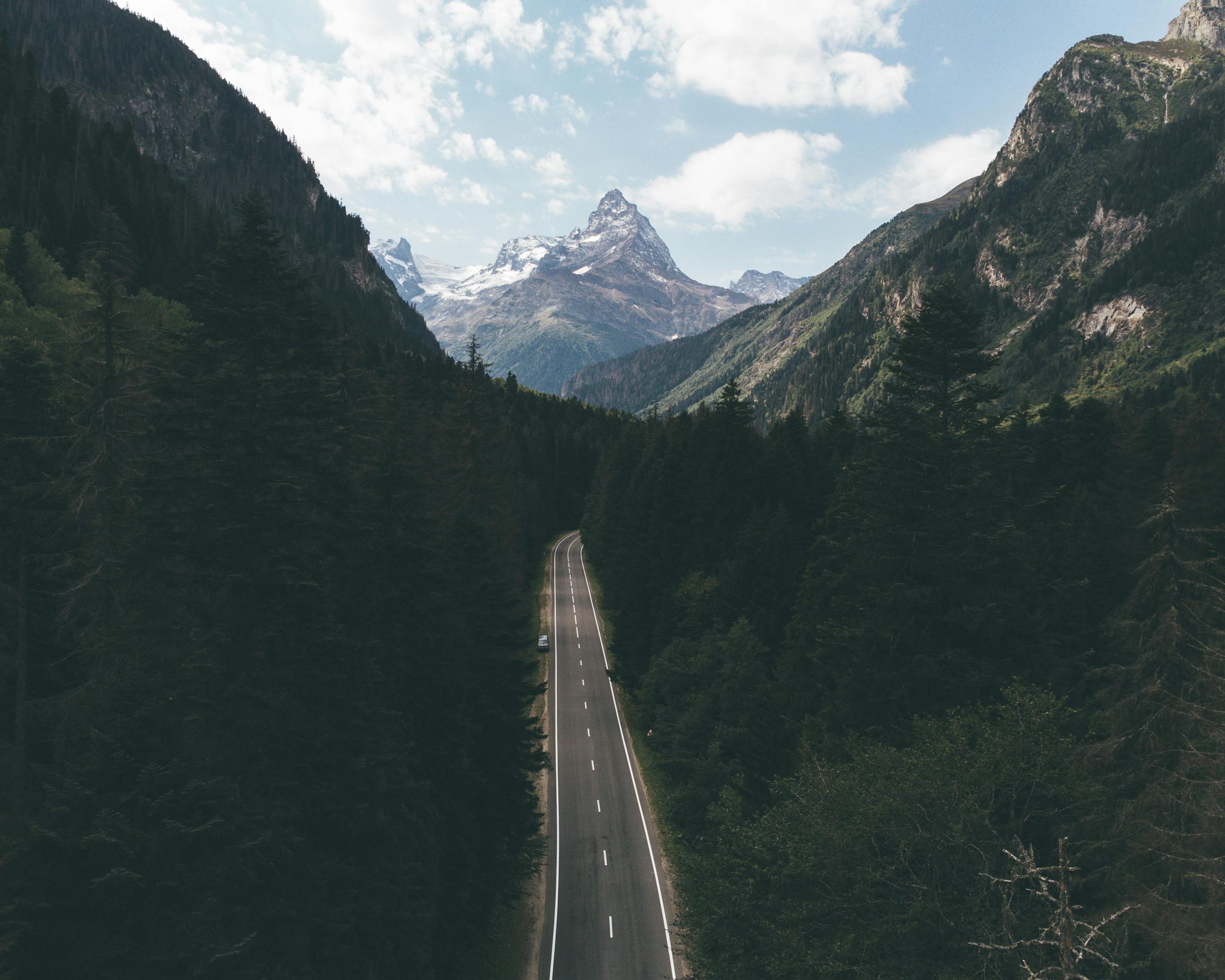 A breathtaking aerial view of a road through the forested mountains in Dombay, Russia.